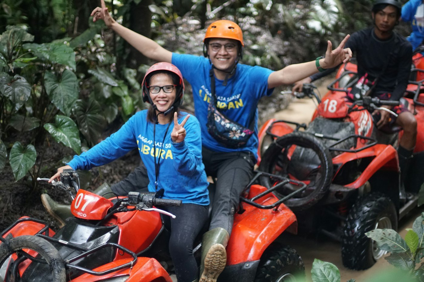 Couple riding ATV quad bikes through the jungle