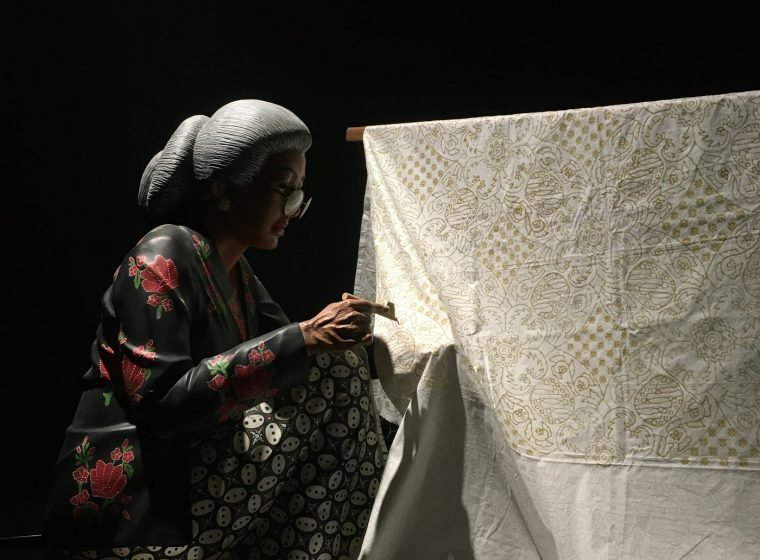 Woman working on a large batik cloth