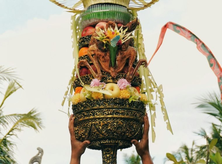 Tall Balinese fruit and flower offering carried at a ceremony