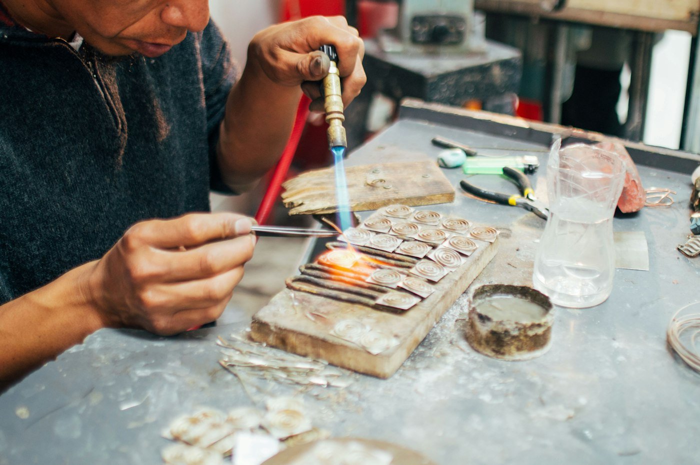 Balinese silversmith soldering silver jewellery at a workbench