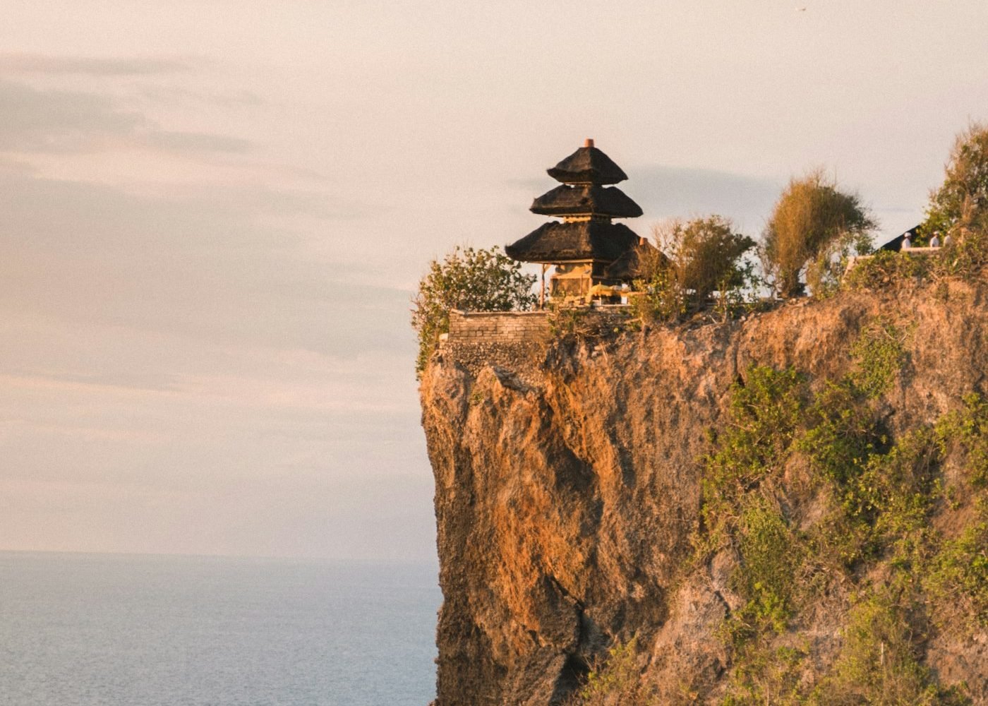 Uluwatu temple on top of a sea cliff at sunset