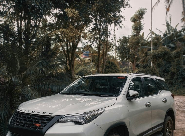 White Toyota Fortuner SUV on a forest road