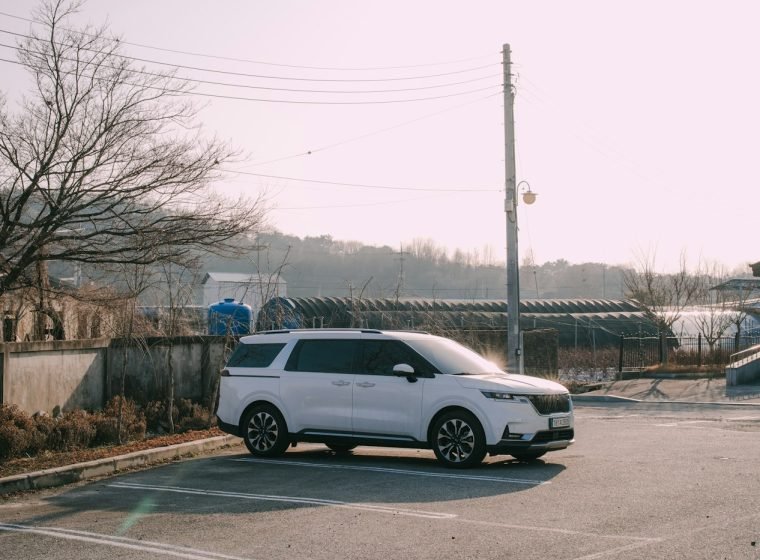 White family minivan parked on a sunny day